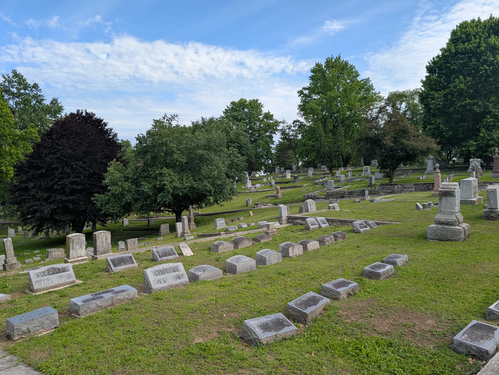 Rows of historic headstones across the green, tree-lined hills of Alton Cemetery