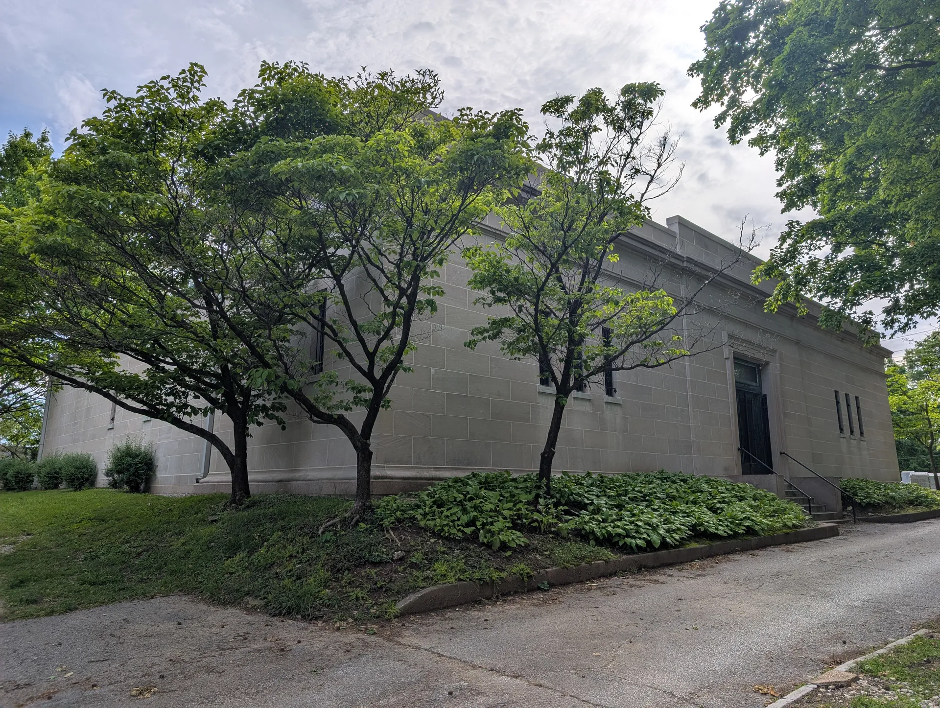 Grandview Mausoleum's stone exterior and entrance framed by leafy trees